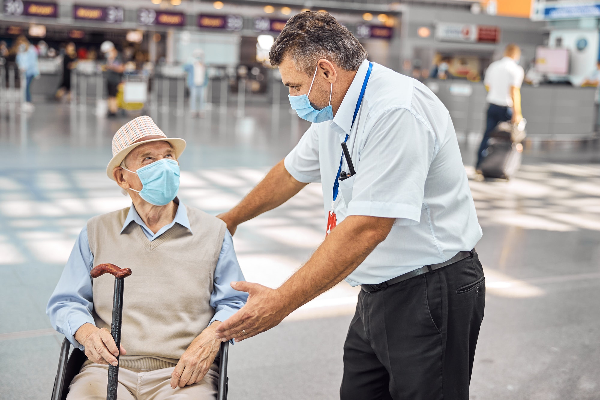 Airline worker communicating with a disabled man
