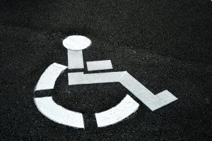 Freshly painted handicap parking sign indicator on blacktop pavement in a parking lot. disabled
